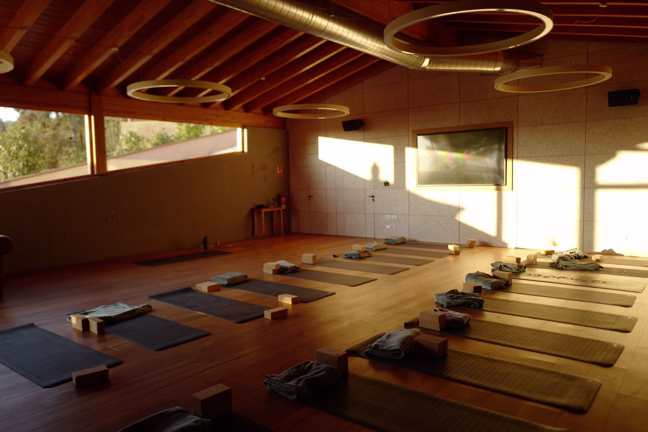 A quiet timber practice room with mats laid out in low afternoon light
